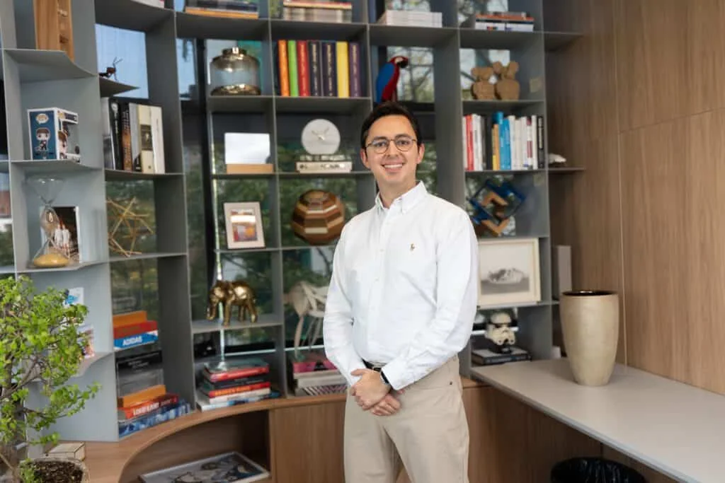 Directivo latinoamericano frente a una interfaz de IA, simbolizando el cambio de liderazgo ante la automatización y la productividad.