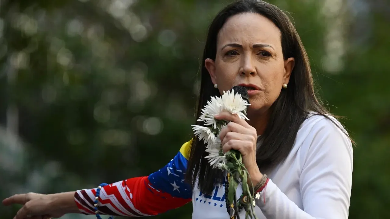 La opositora María Corina Machado saluda a sus seguidores desde una camioneta durante su llegada a Caracas.