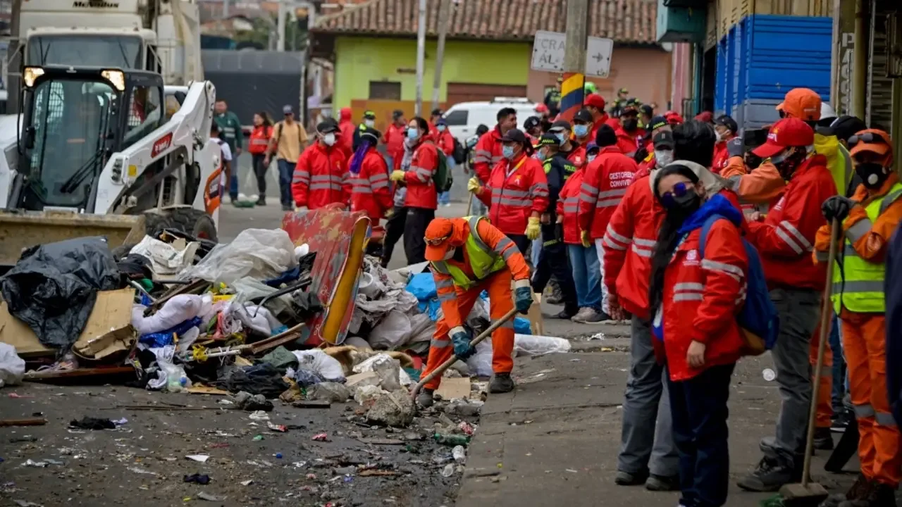 Funcionarios del Distrito y de la Policía durante el retiro de cambuches y residuos en el barrio San Bernardo de Bogotá.