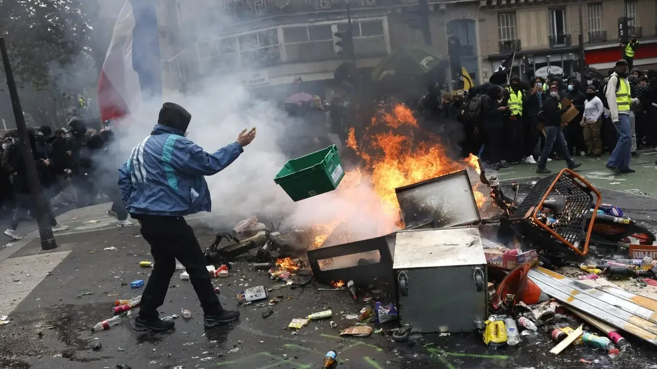 Enfrentamientos entre manifestantes y policía antidisturbios en medio de gases lacrimógenos en las calles de París.